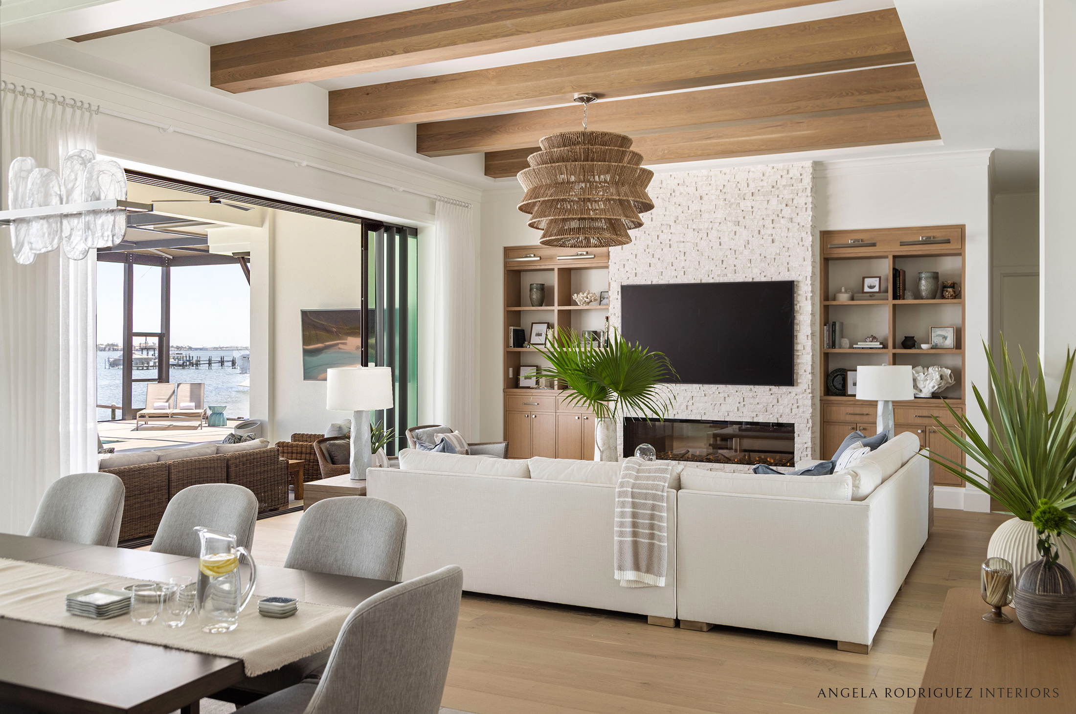Sophisticated coastal great room with ceiling beams and large pendant light