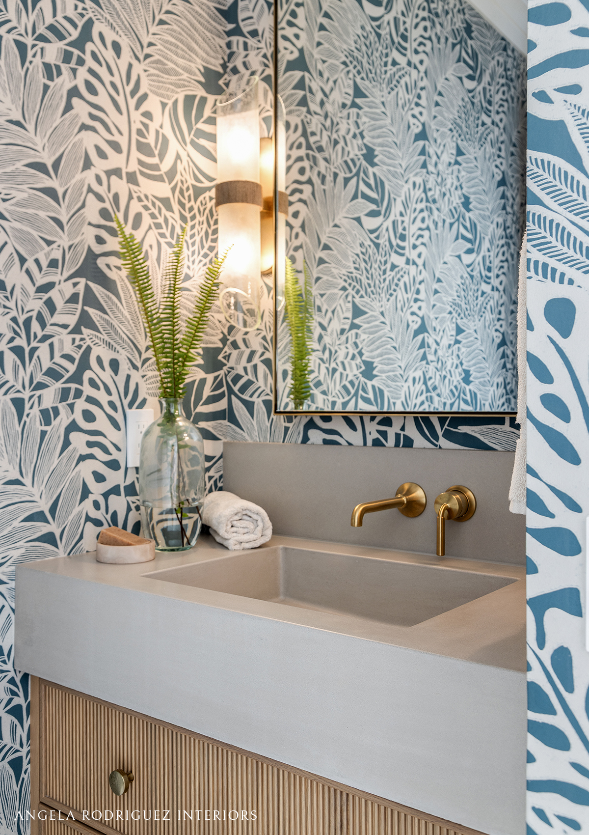 Vanity sink and blue patterned wallpaper