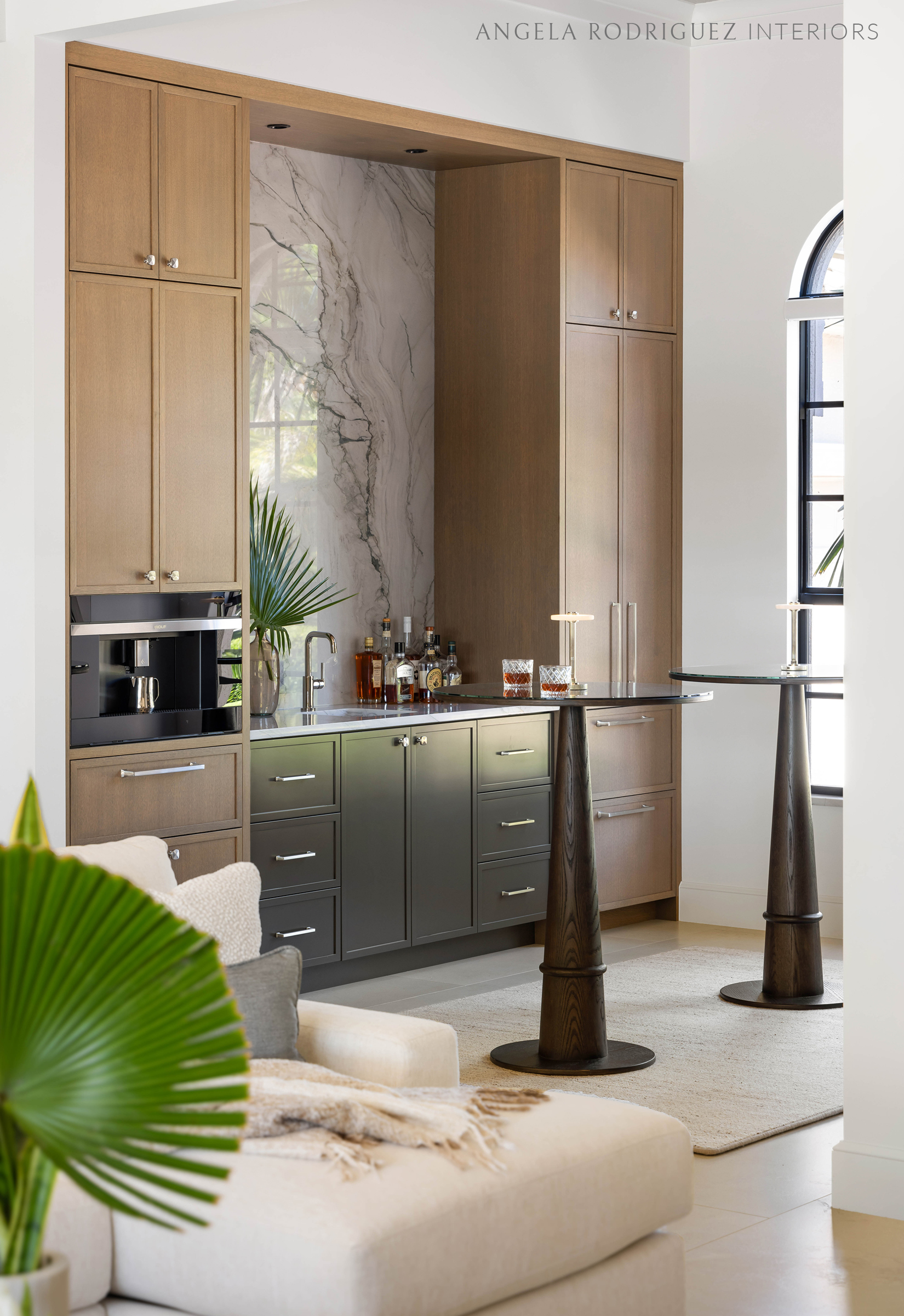 Custom home bar cabinetry in a lounge space with two pub tables